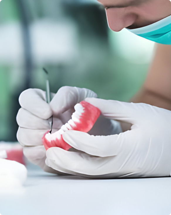 Image d'un dentiste préparant une prothèse dentaire pour un patient